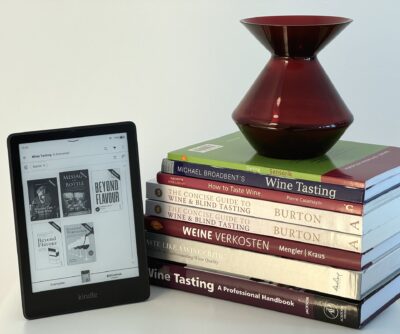 Ebook reader und ein Stapel Weinbücher.